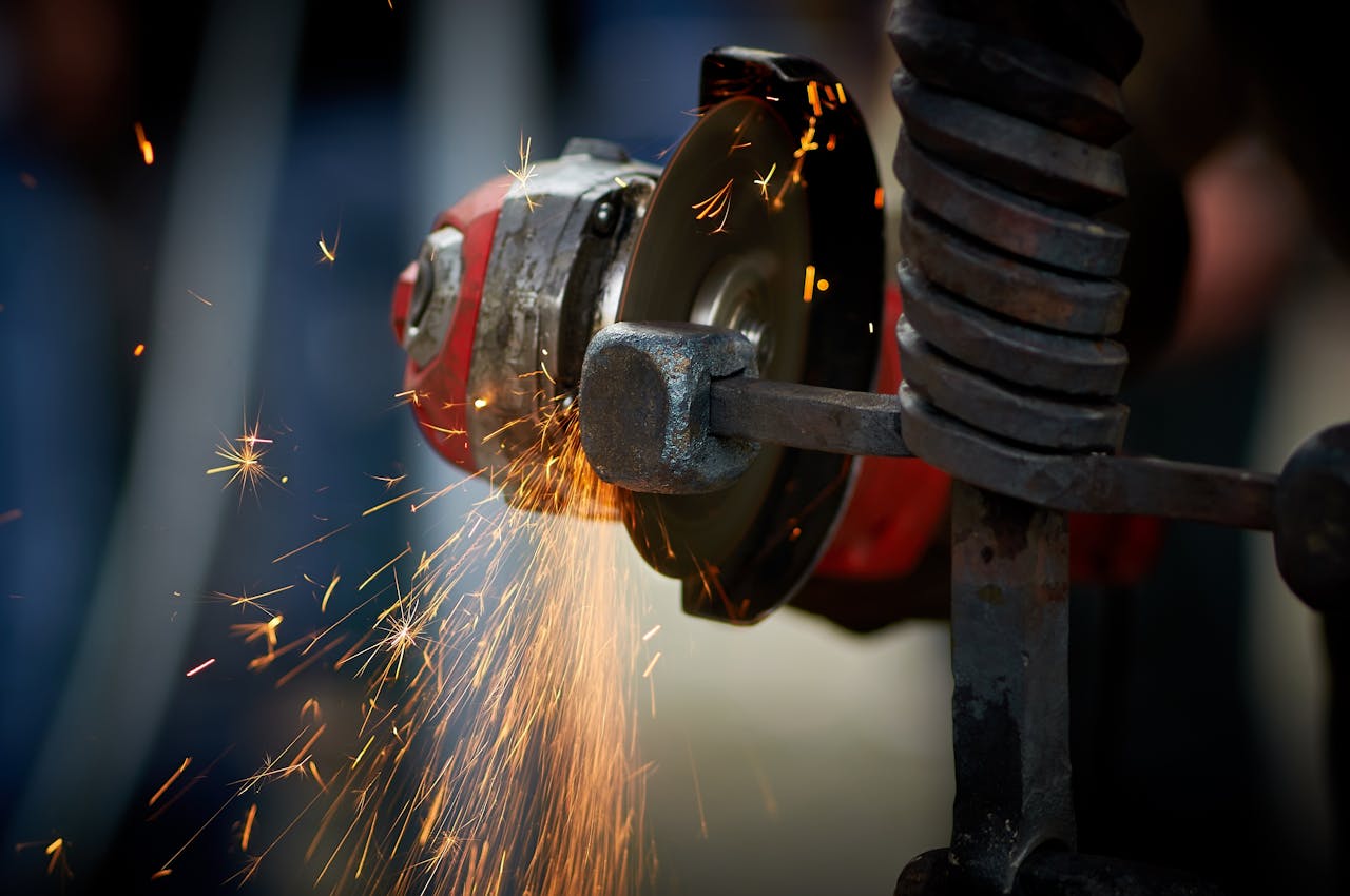 why-choose-us Dynamic close-up of an angle grinder in action, emitting bright sparks as it shapes metal.